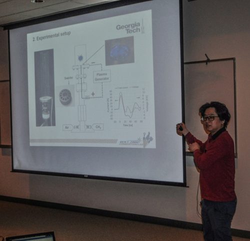 Student giving a presentation using a large white screen. Contents can't be read