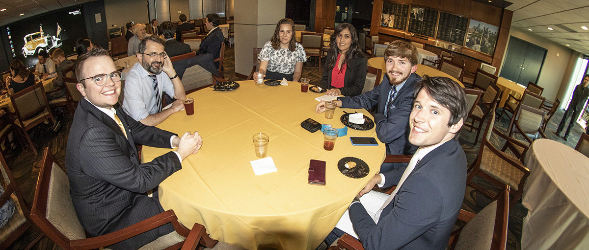 Prof. Joseph Saleh seated at a table with students at the Sigma Gamma Tau banquet