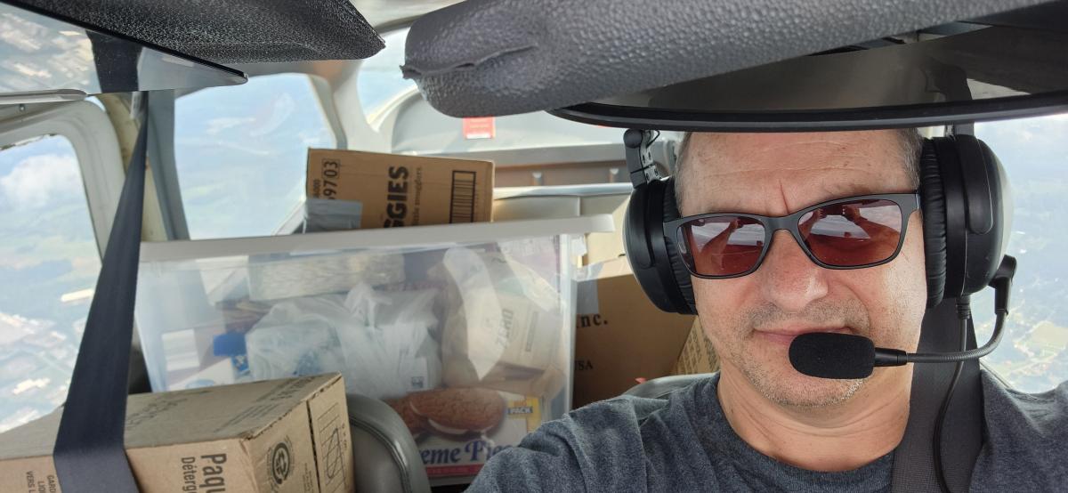 Gary Weissel takes a photo of him midflight with supplies in the back of his plane. 