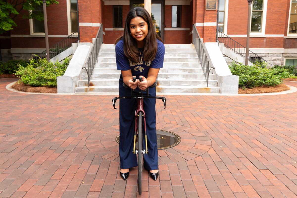 Elise Regalado standing in front of the Tech Tower with her cycling bike used in her triathlon. 