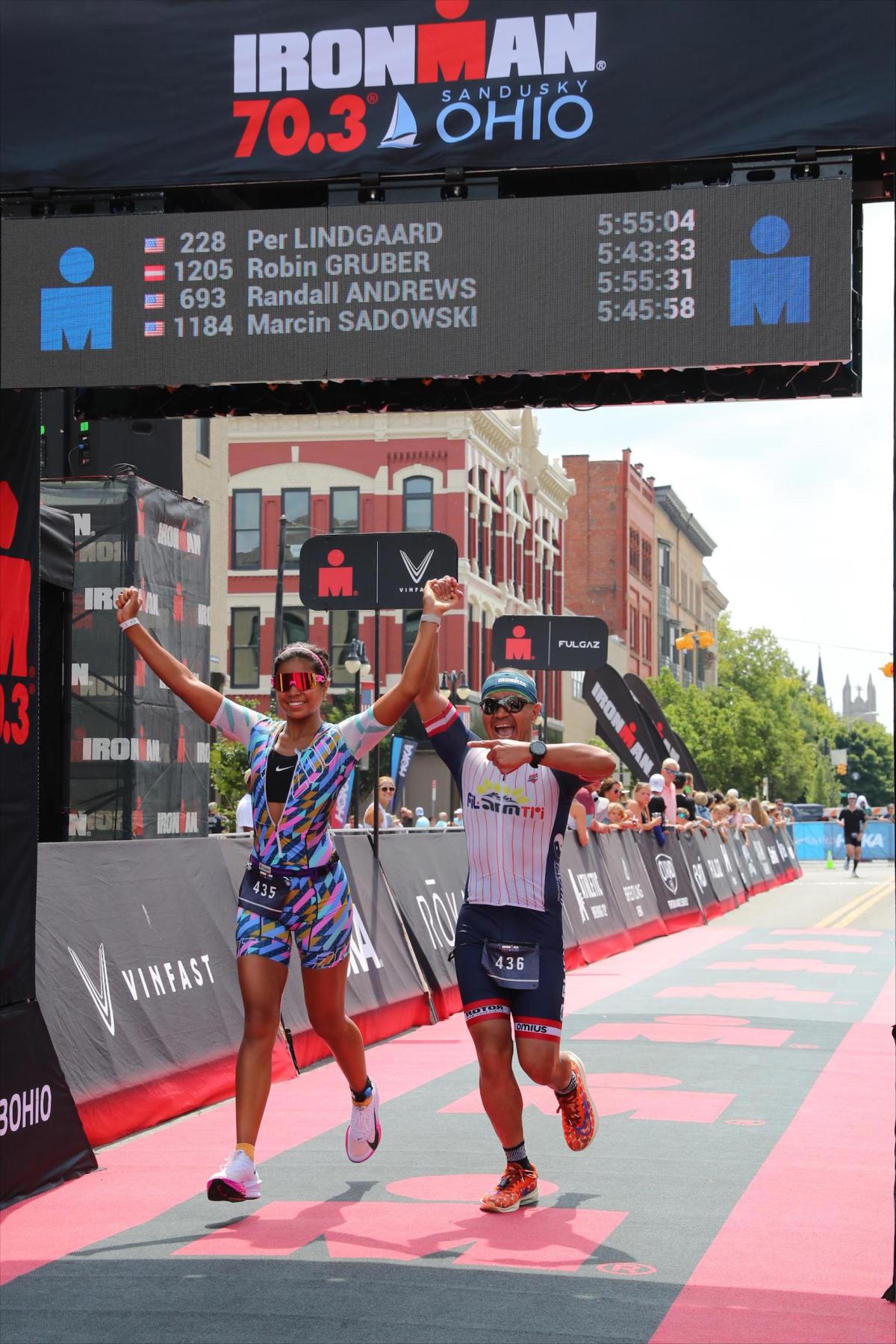 Elise Regalado finishing her triathlon race with her father, Dan Regalado