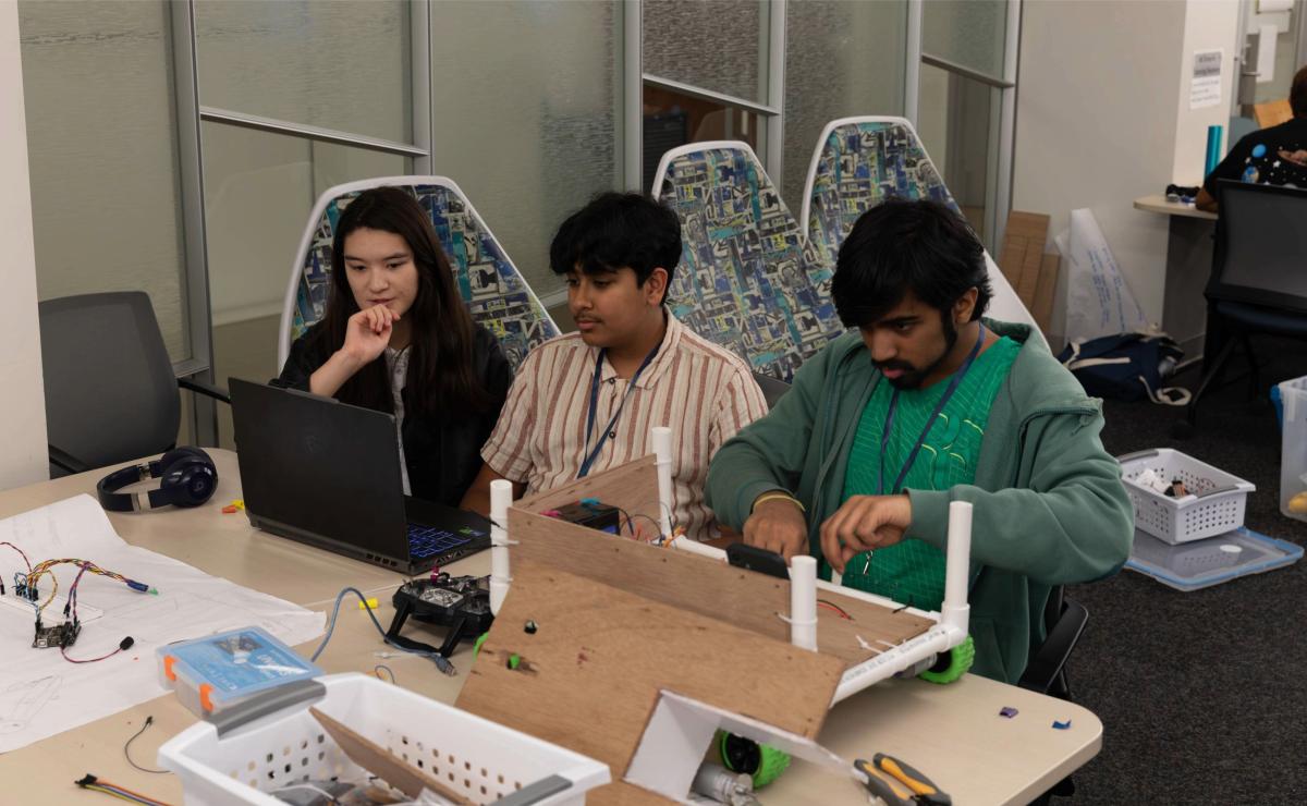 3 students working on rover